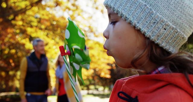 Child Blowing on Windmill Toy in Autumn Park - Download Free Stock Images Pikwizard.com