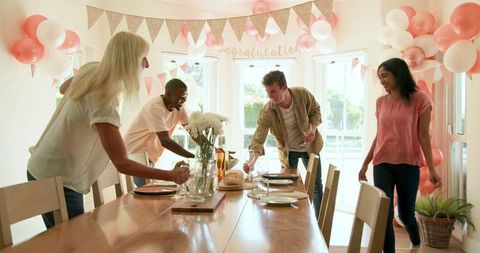 Friends Decorating Dining Table for Festive Celebration at Home