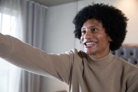 Smiling African American Man Relaxing at Home with Outstretched Arm