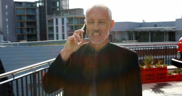 Businessman Talking on Smartphone on Rooftop with Modern Buildings Background - Download Free Stock Images Pikwizard.com