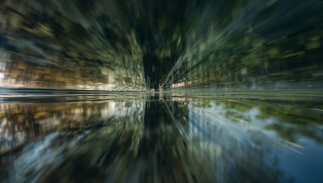 Reflecting canal with radial motion blur creating vanishing symmetry and mirror water