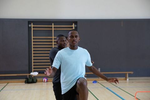 African american athletes performing high-knee agility drill in indoor gym session