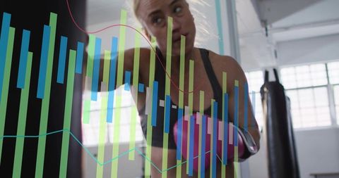 Woman boxer punching heavy bag with data overlay showing performance metrics for training