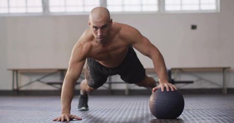 Focused Athlete Performing Medicine-Ball Push-Up for Strength