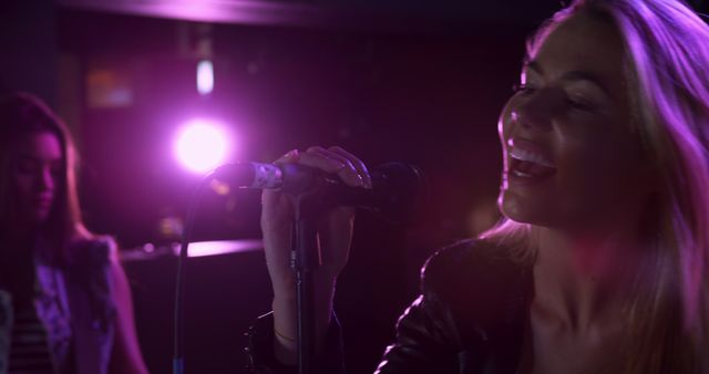 Female singers performing under purple stage lights - Download Free Stock Images Pikwizard.com