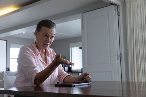 Senior Woman Using Tablet in Bright Lively Home Environment