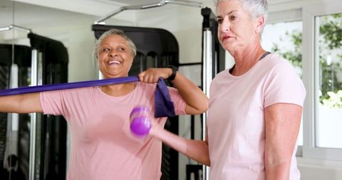 Senior couple enjoying exercise routine with dumbbells and resistance band