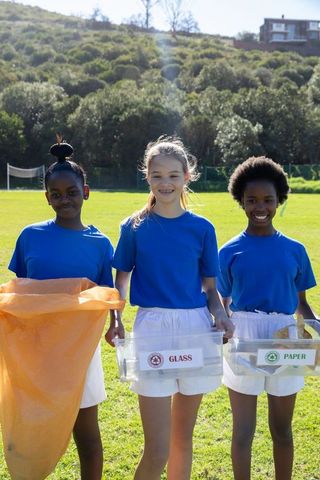 Diverse Schoolgirls Recycling Outdoors Fostering Sustainability