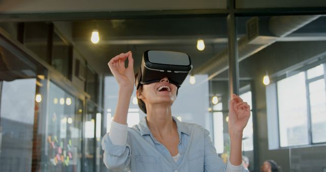 Excited woman experiencing virtual reality in modern office - Download Free Stock Images Pikwizard.com