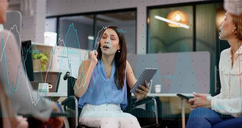 Businesswoman in wheelchair leading team discussion with tablet, charts and data overlays