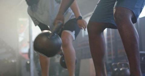 African american men training with kettlebells in moody industrial gym