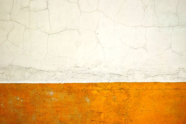 This abstract composition showcases the contrast between a cracked white wall and a textured yellow-orange lower section. Ideal for background designs, urban-themed projects, and digital art. It can also be used for blogs, web design, and any creative projects highlighting textures and patterns.