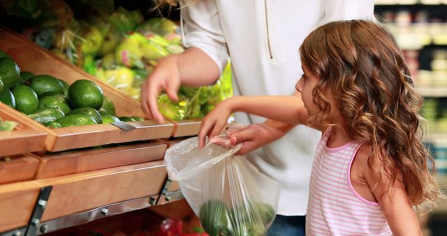 Mother and Daughter Selecting Avocados at Grocery Store - Download Free Stock Images Pikwizard.com