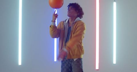 Man Spinning Basketball with Neon Lights in Modern Studio