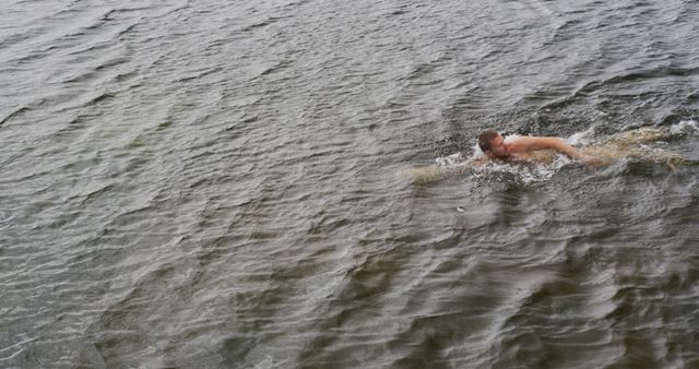 Man Swimming in Open Water during Grey Weather - Download Free Stock Photos Pikwizard.com