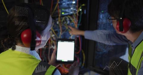Data Center Technicians Collaborating on Server Rack Using Tablet and Safety Gear