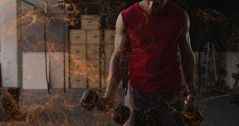 Male athlete lifting heavy dumbbells in industrial gym with dust and dramatic lighting