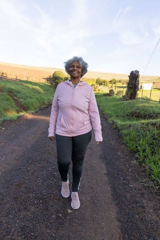 Elderly Woman Enjoying Morning Walk in Countryside