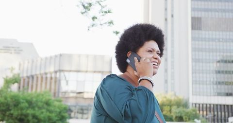 Confident Black Woman Talking on Smartphone and Checking Smartwatch