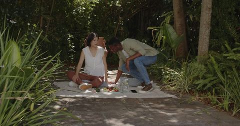 Romantic Young Couple Enjoying Picnic in Sunny Garden