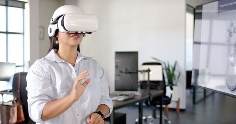 Woman Interacting with Virtual Reality Headset in Modern Office