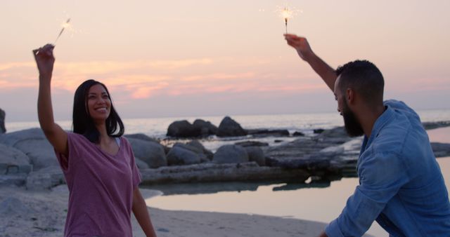 Happy Couple Celebrating with Sparklers at Sunset Beach - Download Free Stock Images Pikwizard.com