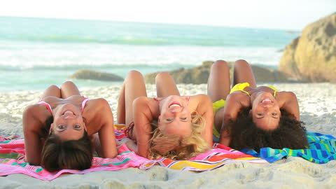 Friends Laughing and Relaxing on Beach Towels