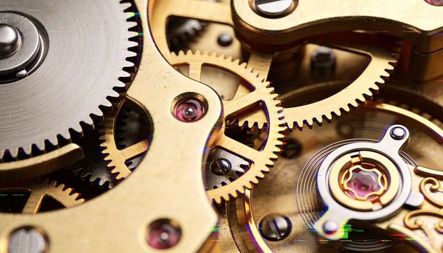 Macro showing vintage mechanical watch movement with brass gears ruby bearings hairspring escapement
