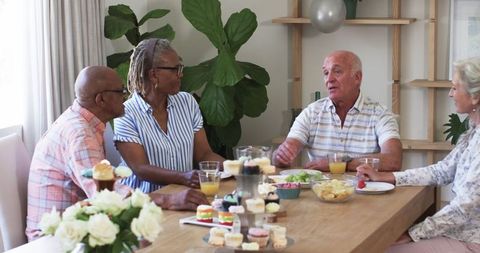 Senior friends enjoying conversation over snacks