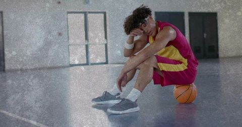 Exhausted basketball player taking a break in gym