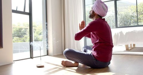 Man meditating at home with incense for peaceful relaxation