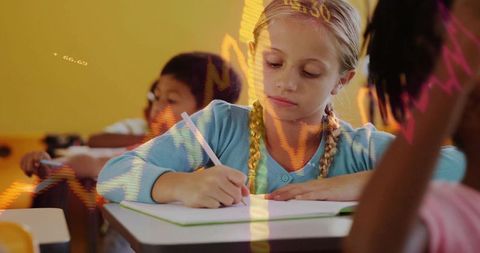 Focused Schoolgirl Writing at Desk with Stationery in Classroom