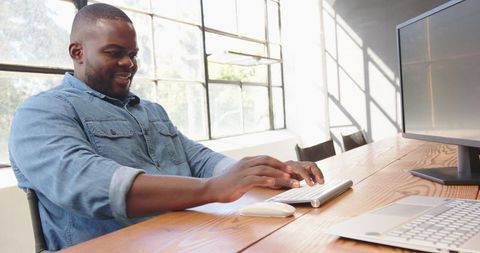 African American Man Typing at Modern Office Desk