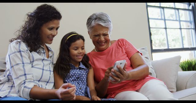 Three Generations Spending Time Together Using Smartphone on Couch - Download Free Stock Images Pikwizard.com