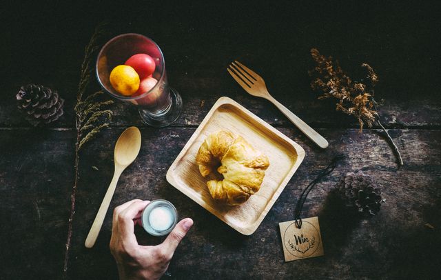 Hand Reaching for Cup with Breakfast Croissant and Fruits on Rustic Wooden Table - Download Free Stock Photos Pikwizard.com