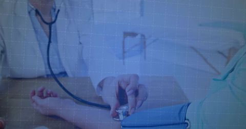 Clinician measuring blood pressure with stethoscope on patient forearm during medical exam