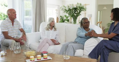 Senior friends enjoying relaxing conversation in cozy living room