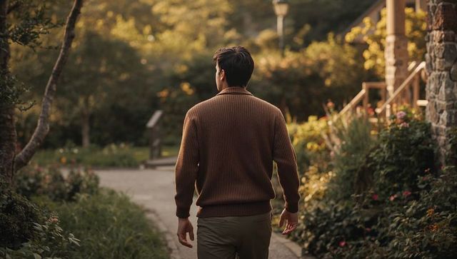 Man Walking Through Autumn Garden Path at Golden Hour