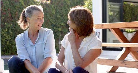 Senior Friends Enjoying Relaxing Conversation at Poolside