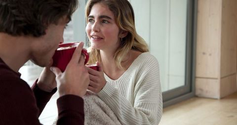 Couple Relaxing with Hot Drinks in Cozy Home Setting