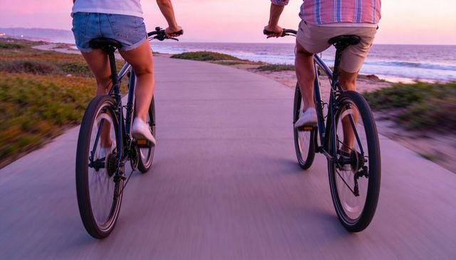 Couple riding coastal bike path at sunset, romantic beach cycling, active lifestyle