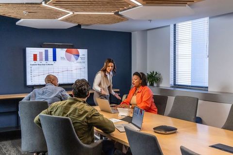 Diverse team presenting analytics dashboard during collaborative boardroom strategy meeting