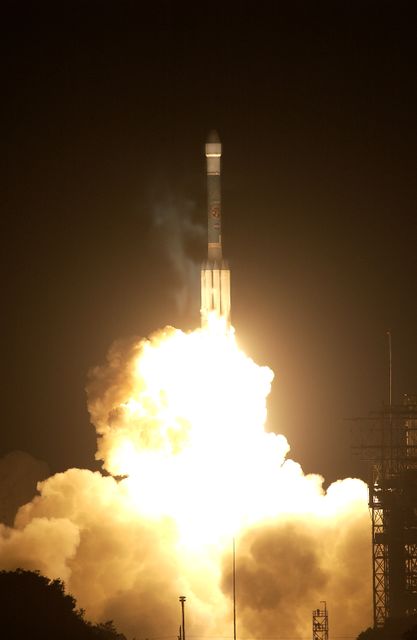 This image shows the Space Infrared Telescope Facility (SIRTF) during its lift-off from Launch Pad 17-B at Cape Canaveral Air Force Station. Captured on Aug. 25 at 1:35:39 a.m. EDT, the rocket blazes upward, illuminating the night sky with intense flames and smoke. SIRTF's mission is to detect infrared energy radiated by objects in space, providing unique insights and views of the universe. Perfect for websites and publications focused on space exploration, scientific discoveries, and NASA missions.