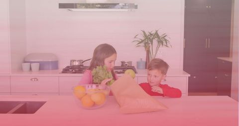 Siblings Unpacking Vegetables Together in Kitchen