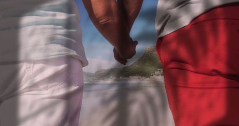 Couple Holding Hands on Scenic Beach with Palm Shadows