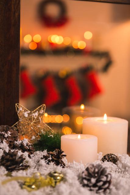Cozy Christmas scene featuring lit candles, pine cones, and ornaments arranged on faux snow. Ideal for holiday greeting cards, festive advertisements, social media posts, or winter-themed promotions.