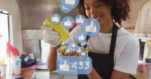 Smiling food truck vendor adding mustard to loaded fries with social media likes overlay