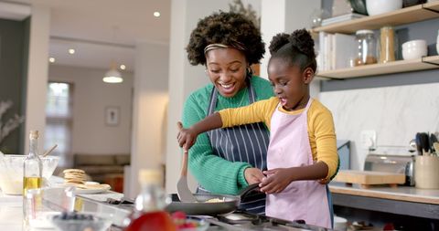 Mother and Daughter Joyfully Cooking Pancakes Together - Download Free Stock Images Pikwizard.com