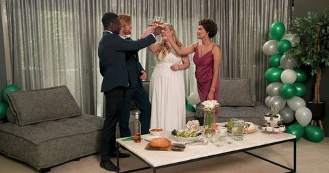 Interracial friends toasting at festive wedding