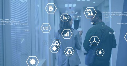 Colleagues walking in office corridor with futuristic sustainability data overlays